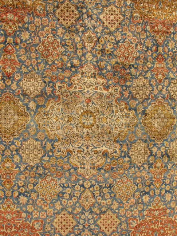 This exquisite antique Kashan carpet, with its remarkable size, showcases multi-faceted cartouches and branching floral motifs and beautifully illustrates the grandeur of sophisticated persian craftsmanship and design. The carpet is exquisitely