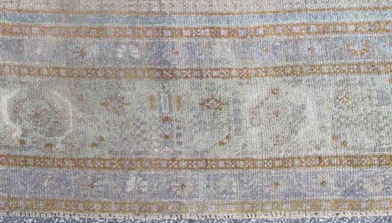 This unique vintage Oushak rug showcases a purple/lavender background with a gold, blue-gray medallion and corners. A main border of soft green and taupe, accompanied by small guard borders of light purple, surrounds the main body of this beautiful