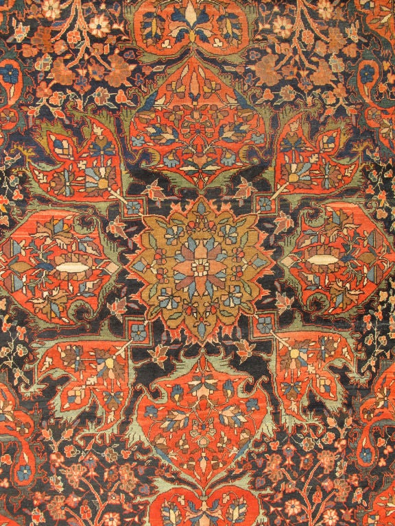 This outstanding antique Farahan Sarouk carpet is primarily characterized by its classical composition and as a prime example of some of the very best achievements of Persian weavers. It showcases floral elements and vine scrolls that are