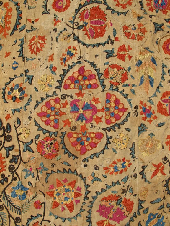 A true jewel of Uzbekistani embroidery, this magnificent antique Suzani is illuminated with a dazzling display of bright colors and exotic design. Because of their exquisite needlework, the highly desirable Suzani was usually presented as a valuable