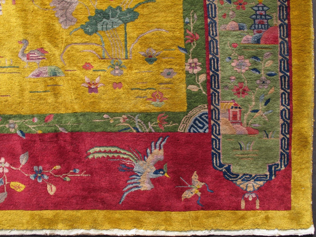 This gorgeous antique Art Deco Chinese carpet has an incredibly rich palette of complementary colors incorporated into a captivating multiplicity of delightful objects of nature. Dazzling flora, oriental vases, musical wind-blown chimes, weathered