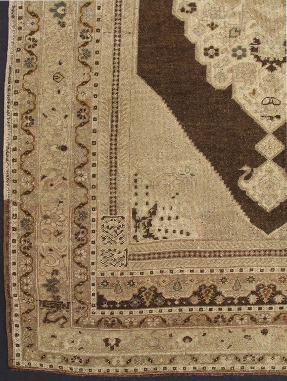 This unique cream and chocolate Turkish Oushak has a center medallion. The cream border has a vine scroll pattern. The center medallion is ivory on a  chocolate brown background with cream and ivory outlines. Very chic.  4'9 x 7'8