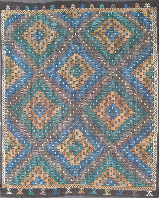 This vintage Jajeem has a large-scale, all-over diamond pattern. Set on chocolate and gray background, the colors include blue, green, yellow. 
Measures: 7'10 x 9'9.