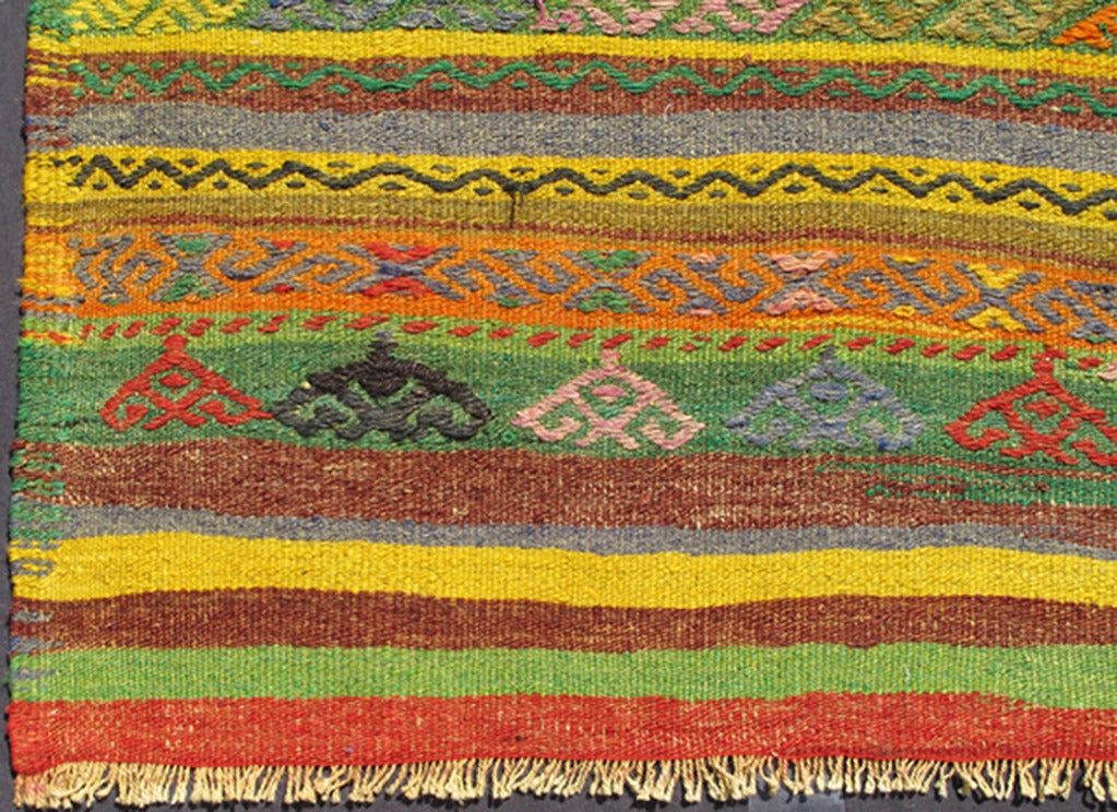 This exciting and colorful striped vintage Kilim from 1950s Turkey features a very vivid and unexpected color combination rendered in various stripe and diamond motif designs.
Measures: 6'1 x 9'1.