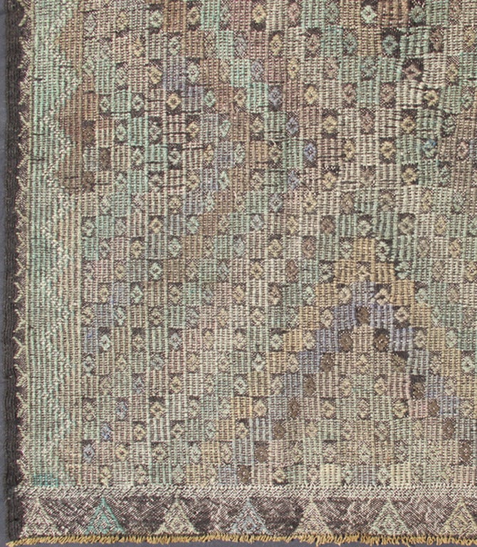 This unique Jajeem features a multitude of diamond shapes in the background combined with a simple outer border. The seemingly random use of pastel colors such as gray, light green, light yellow, brown, cream and lavender enhances the deeply