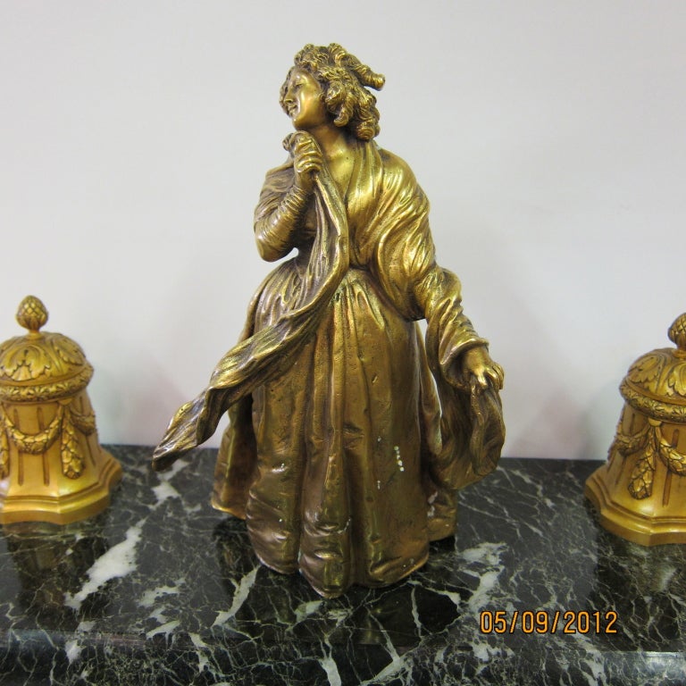 This oversize bronze & marble master inkwell features a demure costumed young
woman holding her shawl as it blows in the wind. The figure is mounted on polished black veined marble & is flanked by two stylish wells with original glass inserts.