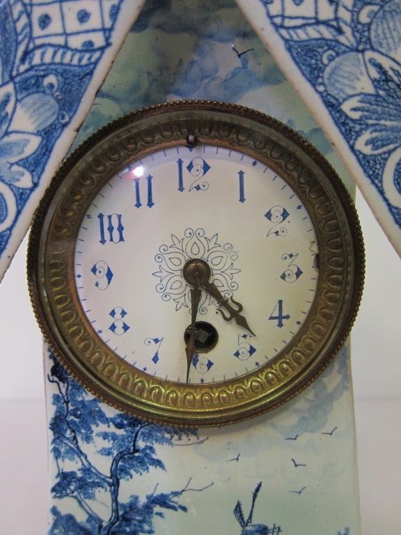 This unique Dutch windmill clock circa early 20th century is sculpted from pottery & hand designed with the traditional blue & white Delft colors. According to its owners, the clock had survived two world wars. The clock is hand painted including a