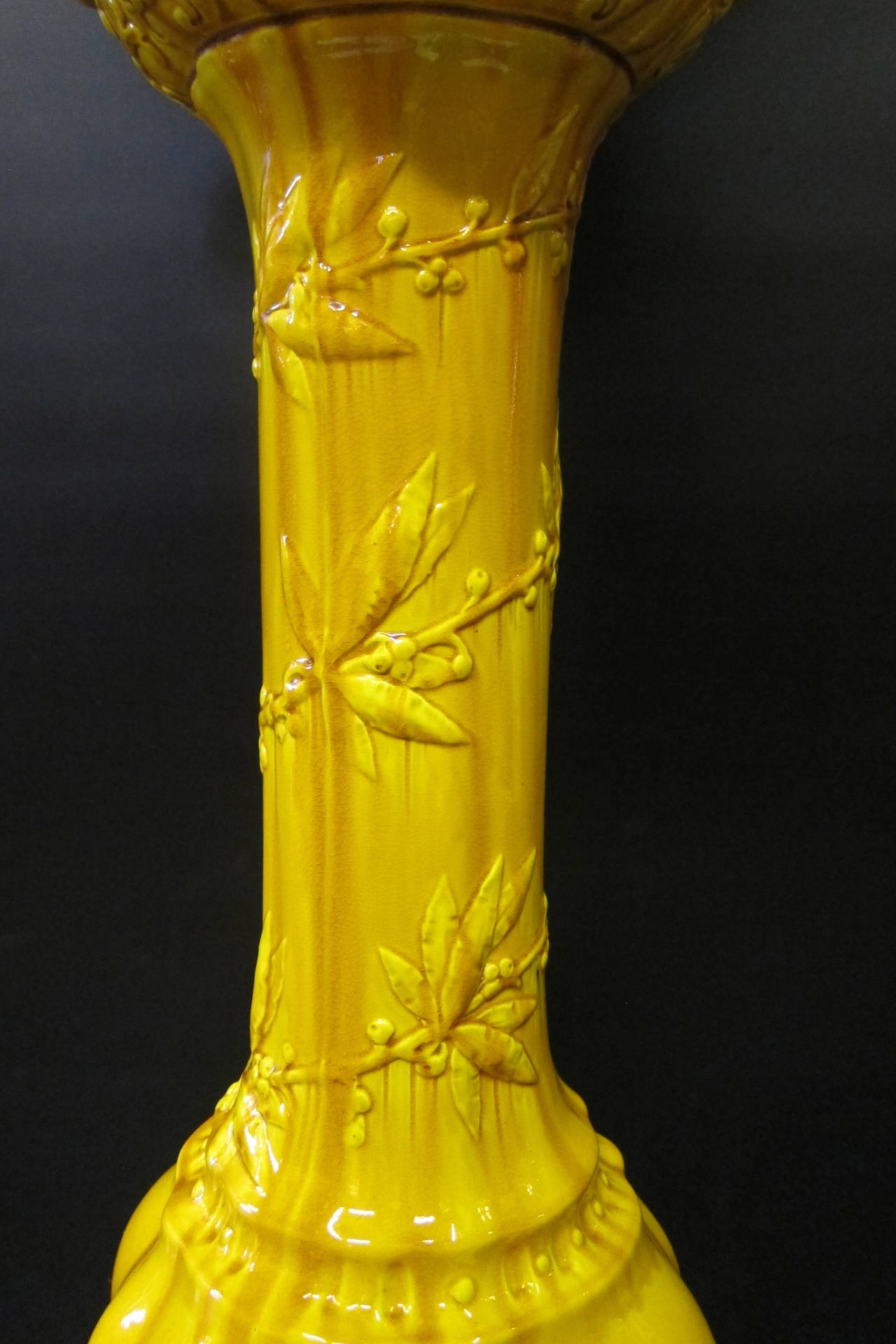 A glowing example of fine English Pottery from the Wardle company. Created in the 19th century, both jardiniere & pedestal are vividly painted in a golden mustard-yellow color. The pottery is designed with a vined berry pattern and accented with a