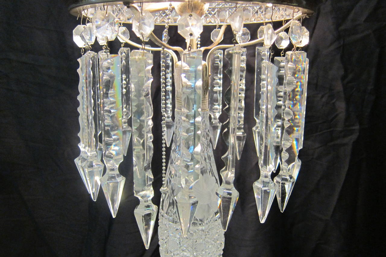 A splendid example of extremely fine cut-glass American table lamps. This circa 1910 beauty is designed with sparkling elongated prisms. The lamp has two sockets with pull chains & works perfectly. Shade & base are in excellent
vintage condition.