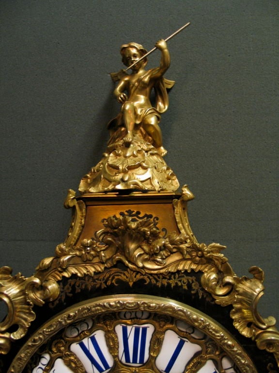 An ornate French boulle mantle clock with extraordinary presence from the late 19th century. This vintage bracket clock is enhanced by highly decorative sculpted gilt ormolu mounts of stylized winged serpents and classical figures that adorn this