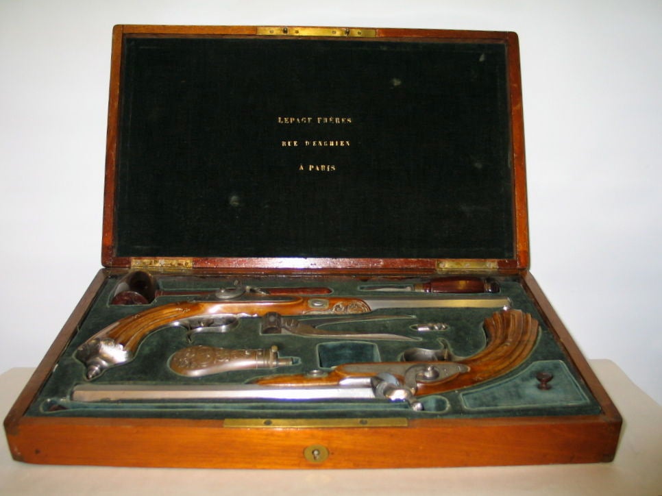 French dueling pistols from the early 19th century in their original display case. These percussion pistols are in superb condition and are offered in their fitted walnut box,  equipped with all necessary components, making them operational. The