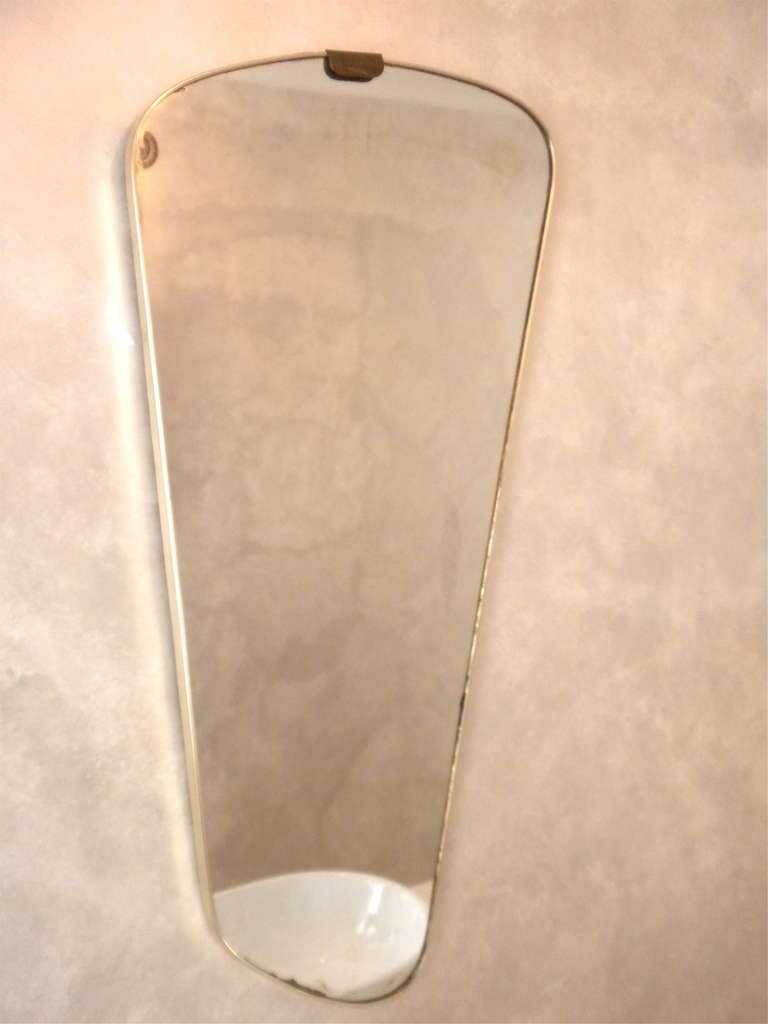 Uniquely shaped brass like frame Mirror from the 1950s, France
Mirror is vintage and shows some antiquing around the edges
Measures 15.25