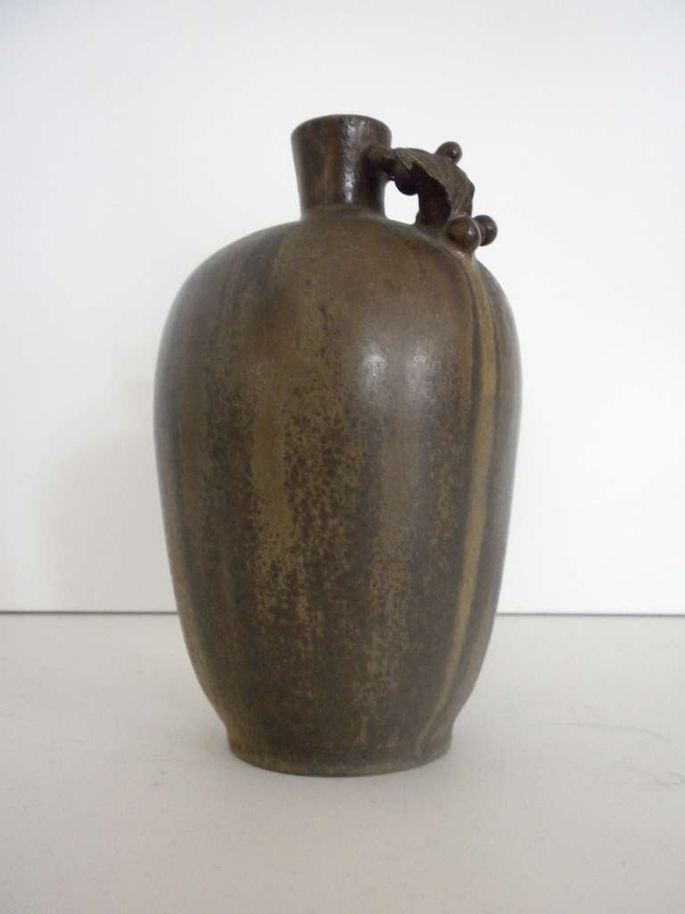 Glazed stoneware vase by Arne Bang with a stylized vine handle.
Signed with monogram “AB” and 