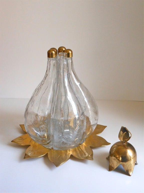 A very rare and exceptional decanter in the shape of a pear or gourd. There are five bottles with brass caps and a large stylized brass lid and all of it sits on a brass tray.