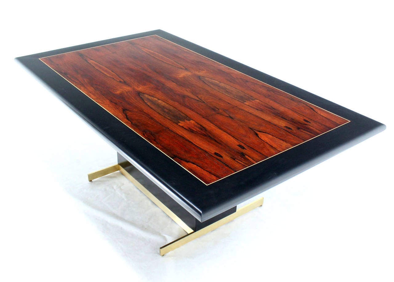 Striking rectangle mid century modern rosewood in ebonies frame top dining or conference table on brass base.