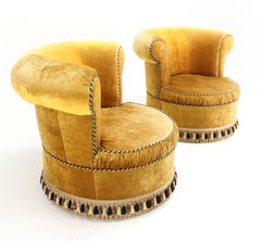 Paire de grands fauteuils de salon en velours doré à dossier en tonneau