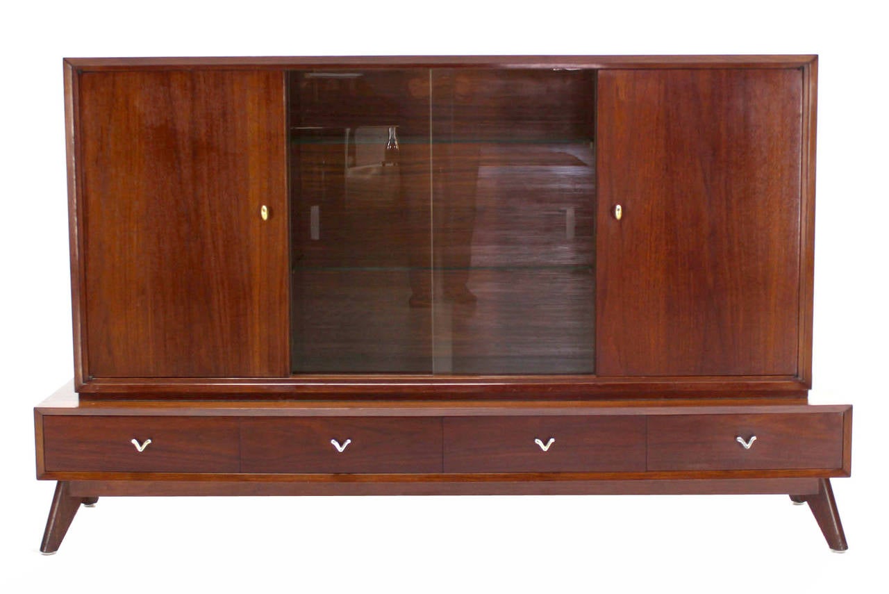 Unusual shape mid century modern two part low china cabinet credenza. Sculptural legs.