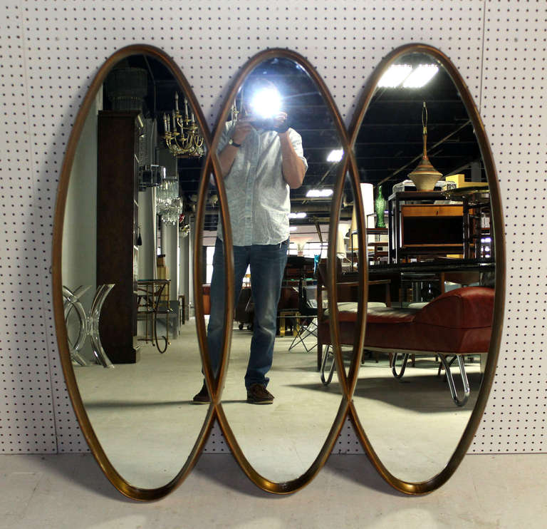 All carved wood jointed into triple oval frame mirror.