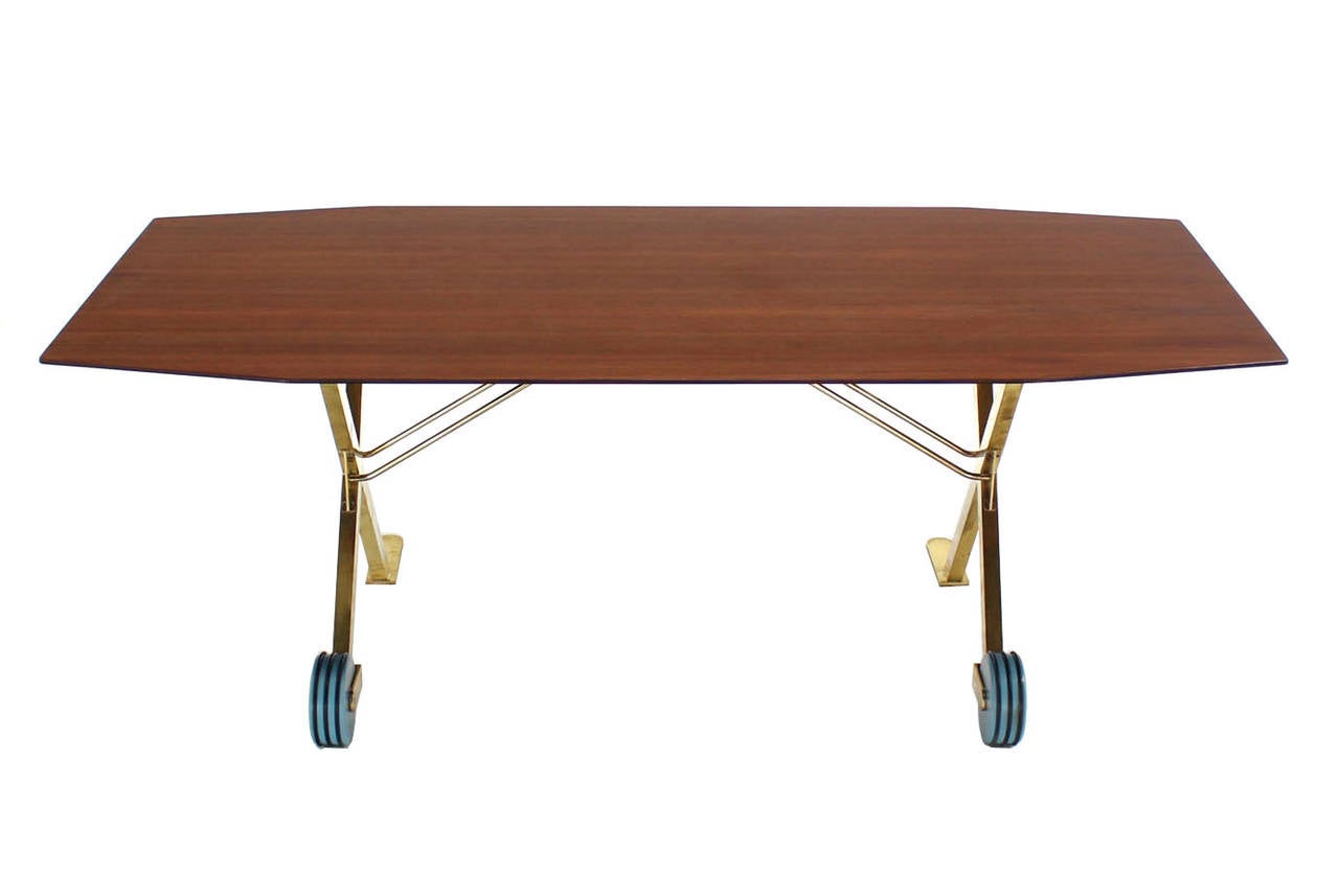 Unusual solid brass base dining table on wheels.