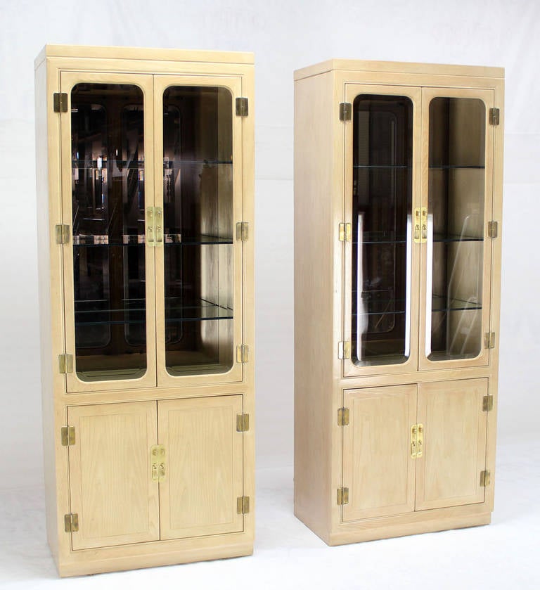 Pair of nice mid-century modern bleached or cerused walnut wall units curio cabinets for John Stuart. Solid brass hardware. Interior cabinets lights.