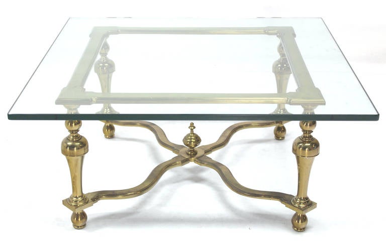 Figural X base square 3/4 inch glass top coffee table with brass finish base.