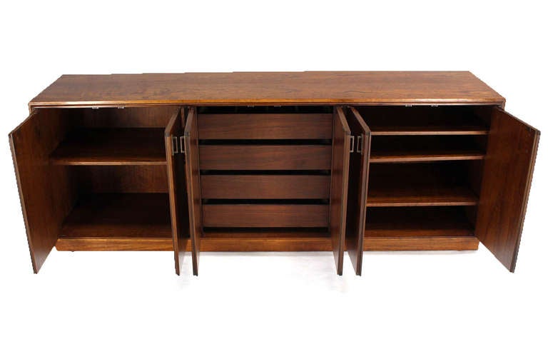 Very nice mid century modern long credenza by Founders. Beautiful dramatic wood grain pattern.  Metal pulls.