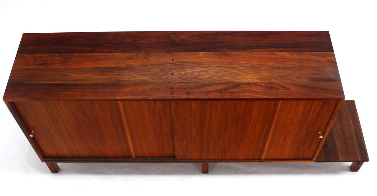 Solid oiled walnut Paul McCobb Style credenza featuring small display area. Solid brass pulls.