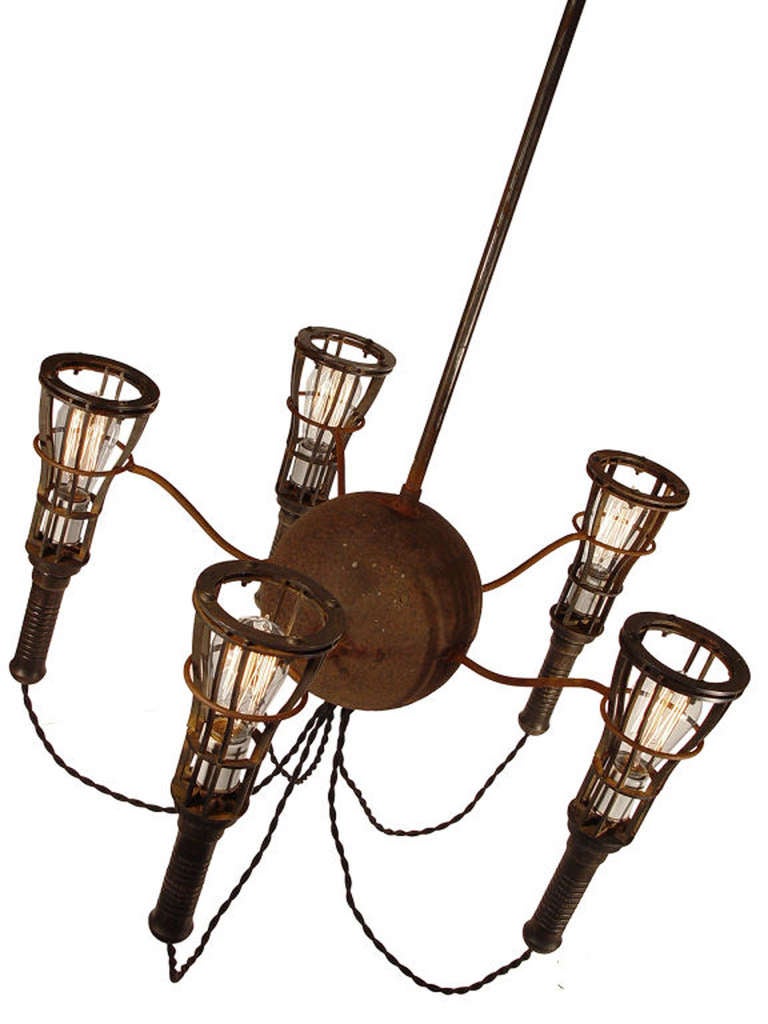 This is a very unique 5 light chandelier. It has an ancient deeply pitted 8 inch hollow ball at the center. You can't duplicate a patina like this. We're guessing it's was originally used as an industrial float of some type. There are 5 matching