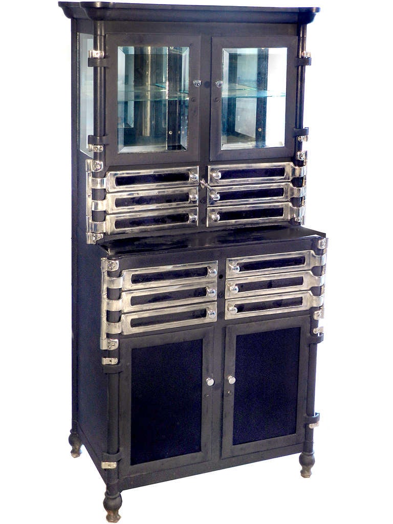 This metal and wood step back dental cabinet looks to be from the Aseptic Dental Cabinet, Lee S. Smith Son & Co., Pittsburgh U.S.A. The unique style of the sculpted top and swing-out trays were this companies signature trademarks. If you are a