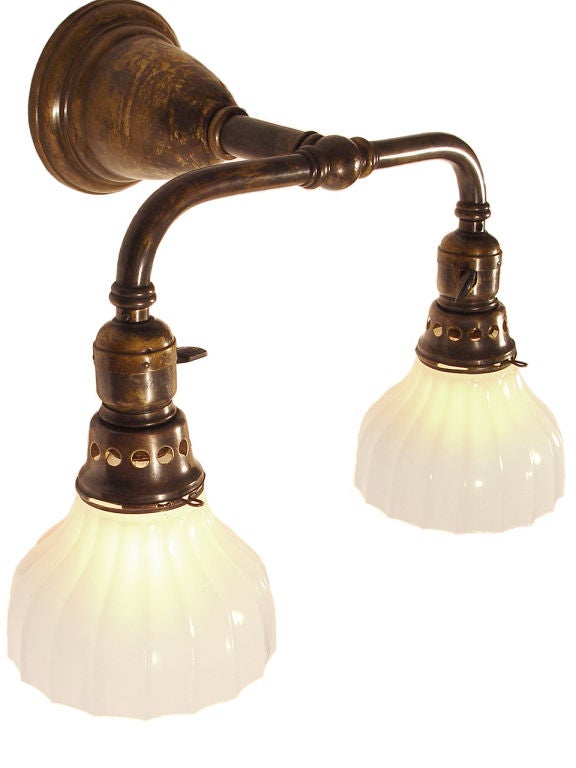 This twin sconce has a nice delicate feel but is extremely well made. I would also say they have an Arts and Crafts feel to them. The 5.25 inch diameter convex fluted milk glass shades have .25 inch thick milk glass and the the brass pipe uses .5