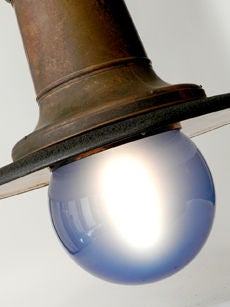 The finish of the original copper and black iron have just the right look. In addition the unique blue glass domes make this matching pair a real standout. The lamp also has some nice bright Japanned copper details on the shades underside. Each has