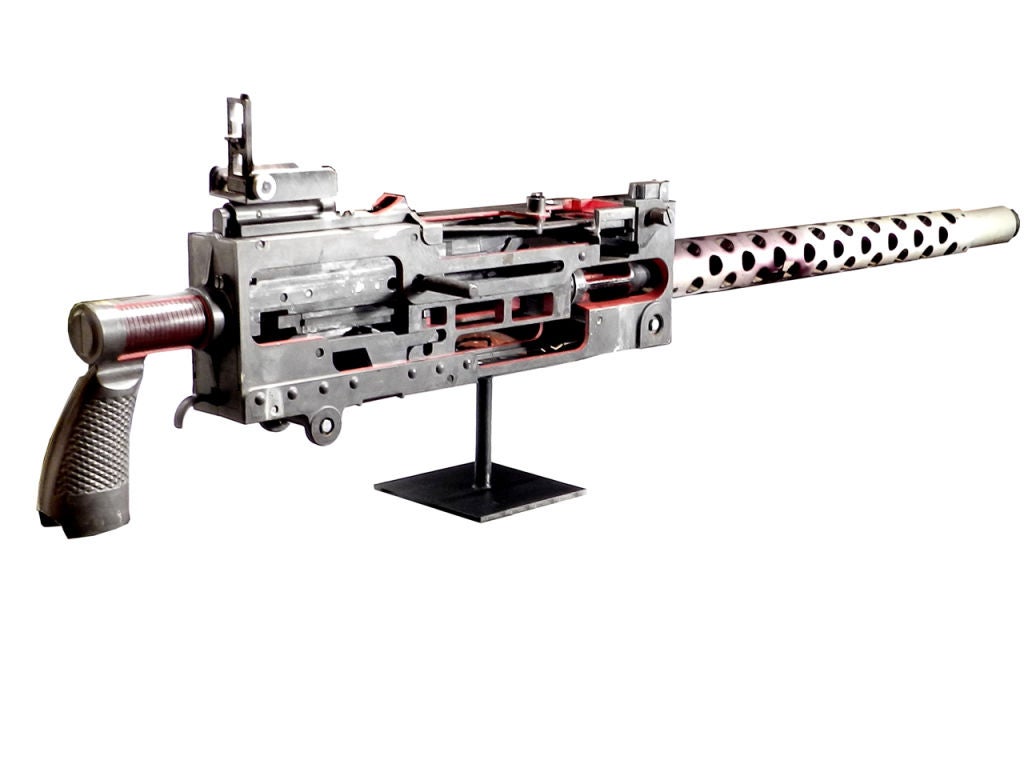 Oversized WWII era cut-away training model of the Model 1919 Machine Gun with an overall length approximately 76 inches. The display is made of aluminum and sheet metal and shows all working parts in detail. It has folding raised front and rear