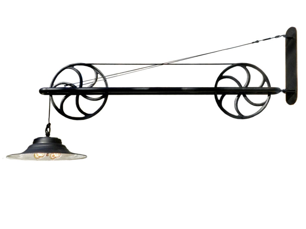 This large dramatic pulley lamp extends from the wall to the lamp center over 68 inches. From the wall bracket top to the bottom of the 15 inch diameter pulley is 27 inches. It easily swings in a full arc from left to right. The striking 20 inch