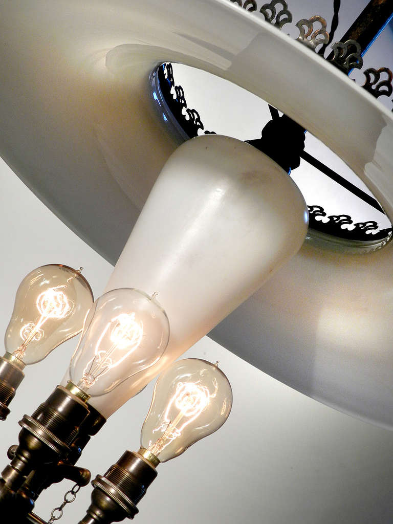 One of these lamps can be difficult to find but here is a matching pair. They have great detail including a large 18 inch tented milk glass shade and brass crown. The central milk glass cone is its most unique feature and something we have not seen