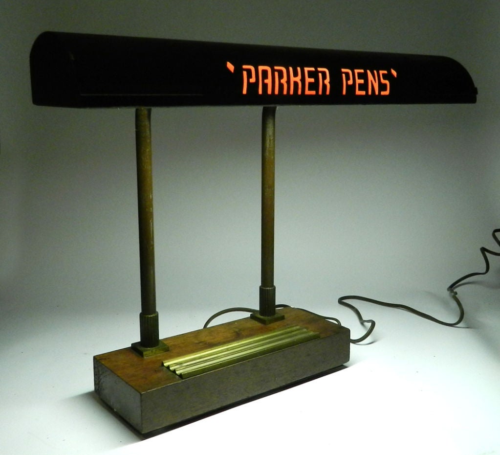 This is an interesting desk lamp advertising Parker Pens. It must have been used as a useful counter display in a pen shop. The letters are cut out of the metal shade and the light shines through. There's a red jell that gives the name the color.