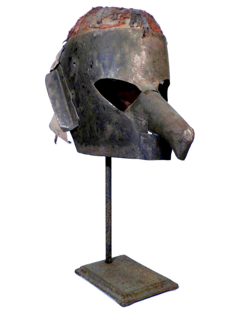 This is a very primitive hand made metal mask. Judging from the patina I'd guess this is late 1800s to 1920s. I don't know if its use was ethnic, carnival or religious... But it does have a powerful presence. All the parts are hand hammered metal