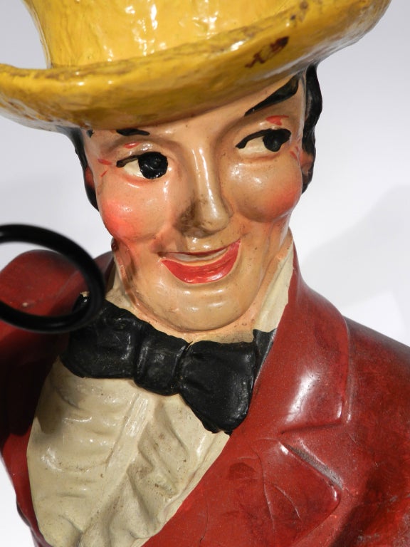 This is an early 20th Century Johnnie Walker Whisky display figure. It's composition with the original paint. It's looks all original including the large gold decal mounted to the wooden base. There may have been a bit of early touch up on the left