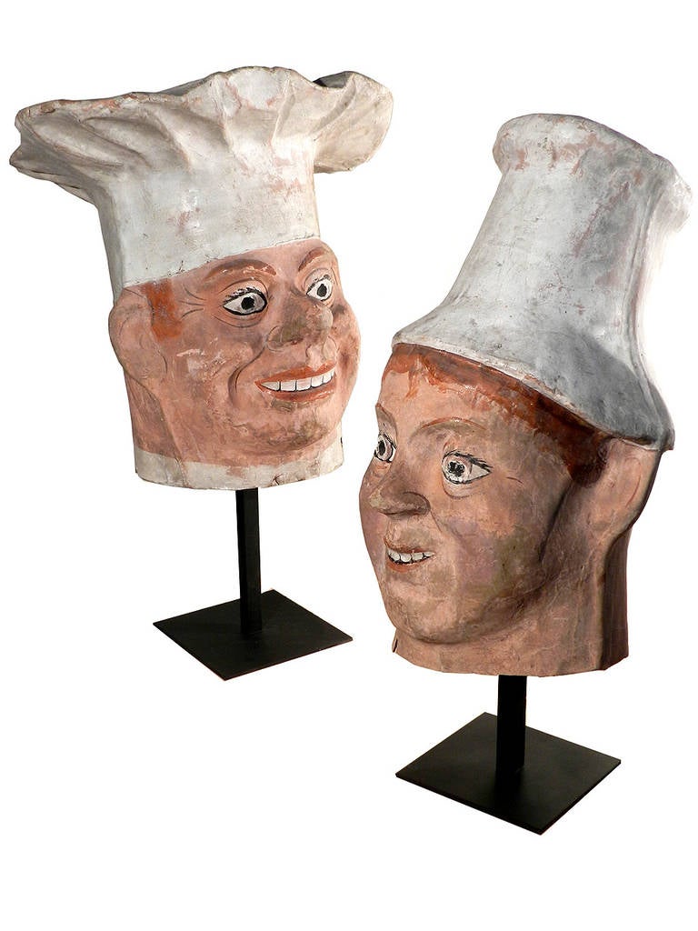 We just returned from Paris and came home with 2 French chefs. These are early full head paper mache carnival masks. They have great character and detail. Both include custom iron display stands. The tallest stands 26 inches