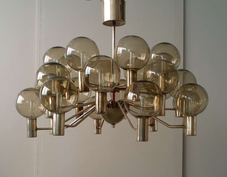 A large 24 light chandelier by Hans-Agne Jakobsson designed for A/B Markaryd. The smoked glass shades held in a solid brass fixture. Showing the manufacturers label.