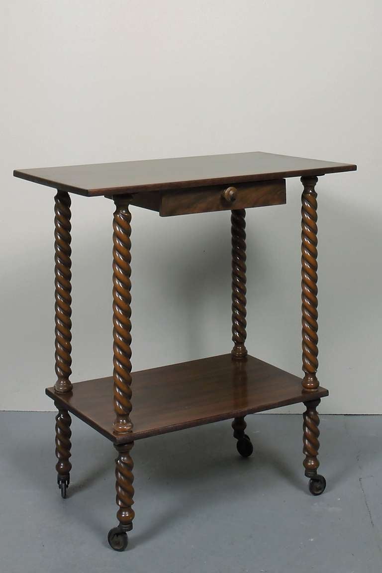 A two two teared tea cart of Italian walnut. The turned legs on casters.
