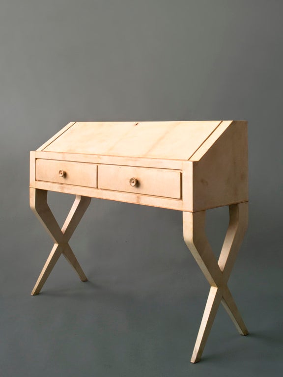 A parchment covered desk with maple details. Holding two drawers under the slanted front.