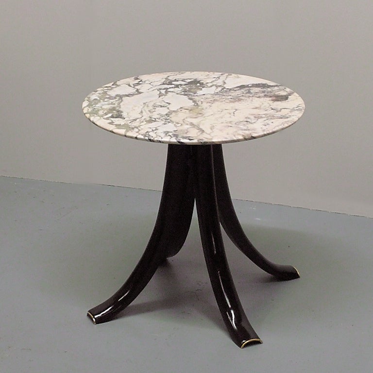 A rare occasional table with a vanilla colored Carrara marble top and stained cherry wood legs with brass ends. 

Literature: Gramigna, Giuliana and Irace, Fulvio, Osvaldo Borsani, Roma, 1992