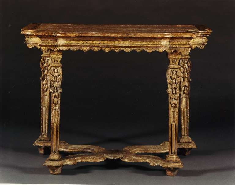 The shaped inset lumachella marble top with a painted molded edge above a molded frieze with a continuous shaped apron, the whole raised on four square tapering legs carved with acanthus leaves and harebell pendants, the legs joined by a shaped