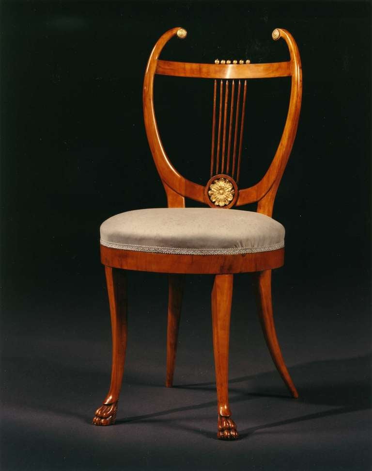Each with back of lyre form with carved roundels and a carved rosette, the circular upholstered seat raised on four sabre legs the front pair terminating in carved paw feet. Detailed research report available on request.