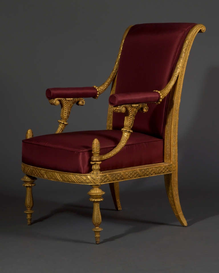 The rectangular back with scrolling top-rail, the sides with intricate punched repeat floral patterning, the arms resting on carved foliate scrolls, the seat-rail carved as a continuous laurel wreath with conforming floral pattern punched to the