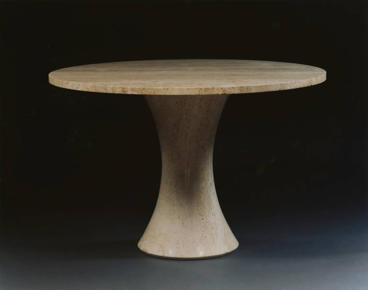 A travertine circular dining table designed by Henry Moore and made under his direction at the Henraux Marble Works, Querceta.

The circular top raised on a waisted stem with faceted edges. Detailed research report available on request.