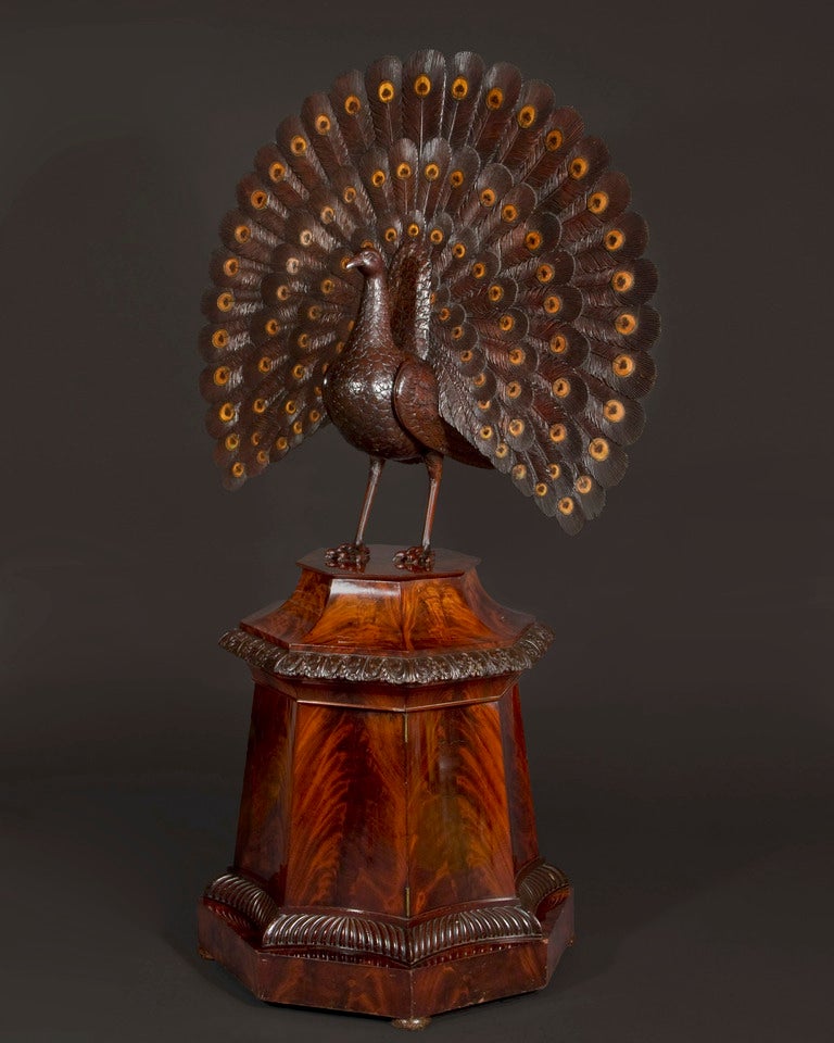 Of mahogany inlaid with holly and boxwood, the interior with cherrywood drawers lined with maple, the fittings of silver gilt. The peacock with train in fan display with inlaid eyes stained green, the neck and head dropping forward to reveal a work