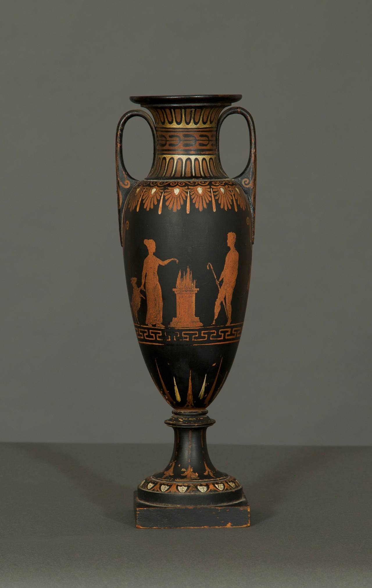 Of black and red painted wood simulating Greek red figure pottery in the form of an Amphora, depicting animals and figures performing a sacrifice. Detailed research report available on request.