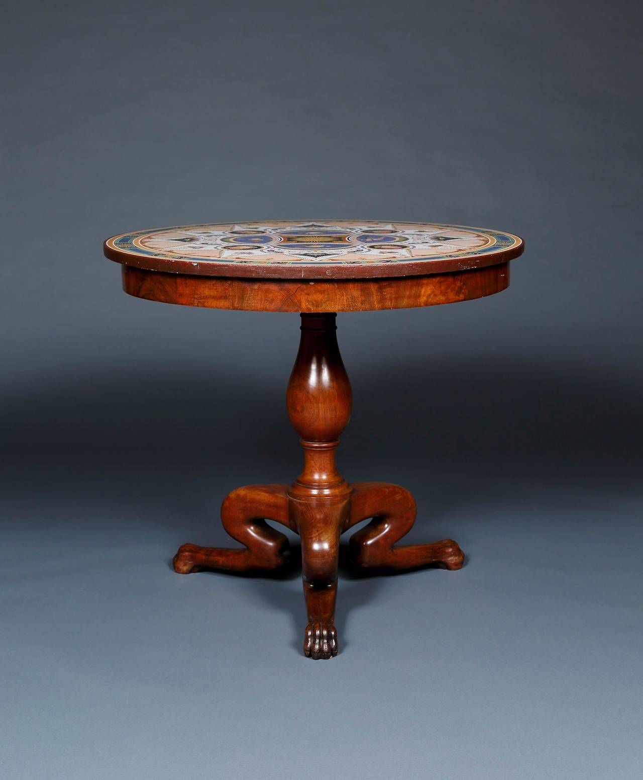 A VERY RARE POLYCHROME CIRCULAR TABLE-TOP EN ÉMAIL SUR LAVE DE VOLVIC DESIGNED BY JACQUES IGNACE HITTORFF AND MANUFACTURED BY HACHETTE ET CIE, RETAINING ITS ORIGINAL CARVED MAHOGANY TABLE BASE

The top decorated with Pompeian style grotesques,