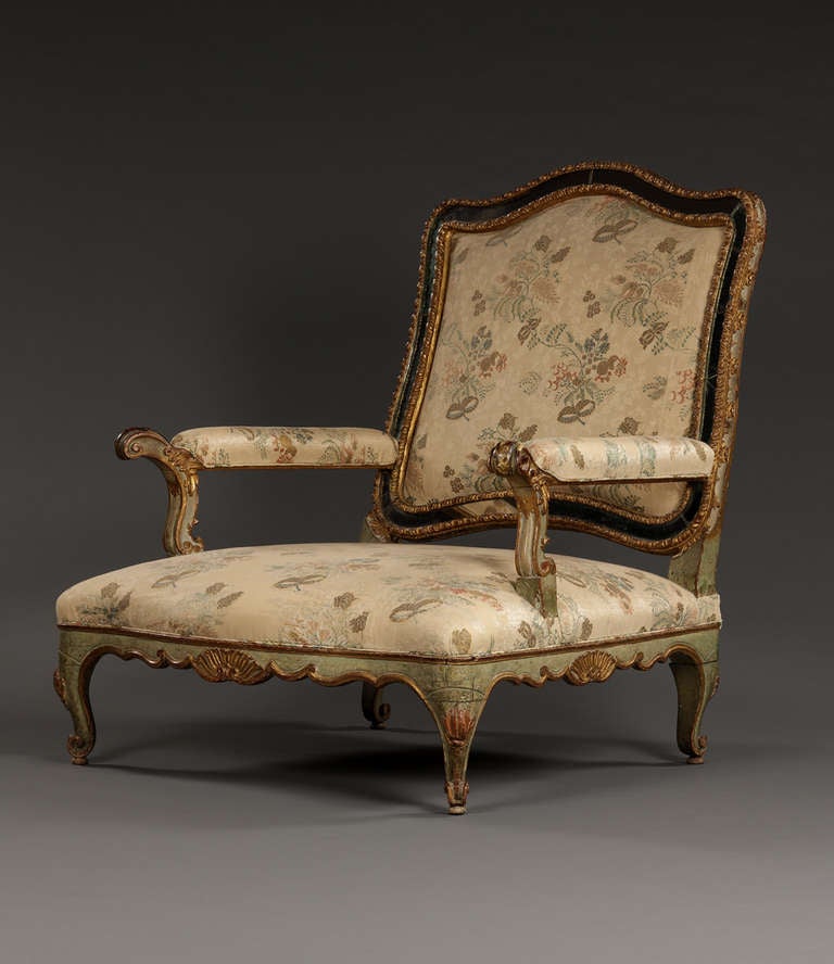 Most unusually, the present armchair incorporates original mirror glass insets bordering the backrest. There are very few 18th century examples of this practice. The upholstered backrest with old, possibly original, floral colored fabric. The